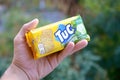 Tuc snack pack in male hand on a green trees background