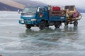 A breeder carries his horses in a truck on the frozen lake