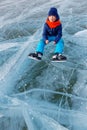 Young skater sitting on an natural ice rink on Khovsgol lake