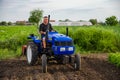 Kherson oblast, Ukraine - May 29, 2021: Farmer on a tractor works in the field. Seasonal worker. Recruiting workers with skills