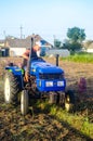 Kherson oblast, Ukraine - September 19, 2020: A farmer on a tractor with an aggregate of equipment for digging potato. Farming