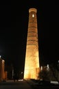 Street market in front of Islam Khoja Madrasa and minaret in the old town at night