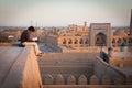 A lonely tourist sitting on the roof of one of houses in Old City of Khiva