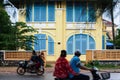 Khmer people riding motorcycle pass old french colonial building. Scenic landscape town of Kampot, South Cambodia, ancient Royalty Free Stock Photo