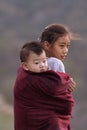 KHONOMA VILLAGE, NAGALAND, INDIA, December 2016, Young Naga girl carryies sibling on her back