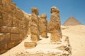 Khufu pyramid seen from ancient ruins. Pillars and stone fragment with Egyptian hieroglyphs