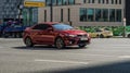 Kia Cerato Koup First generation TD in motion on a city street. Red coupe car Kia Forte Koup, front side view