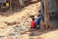 two African women near the huts are talking among the garbage