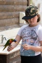 Parrot Lori - Loriinae - sits on the arm of the girl and eats an apple at the Gan Guru Zoo in Kibbutz Nir David in Israel