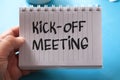 Kick-off meeting, text words typography written on paper against on blue background, life and business motivational inspirational