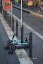 Kick scooters lying next to several short columns on the street