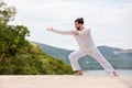 Kickboxer or muay thai fighter Man in white training karate Wushu on mountain Royalty Free Stock Photo