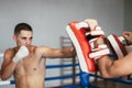 Kickboxer training with partner in boxing paws Royalty Free Stock Photo
