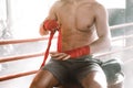 Kickboxer wraps his hands red bandages. Cropped image without face Royalty Free Stock Photo