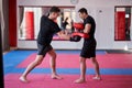 Kickboxing fighter hitting pads with trainer