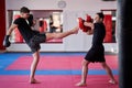 Kickboxing fighter hitting pads with trainer