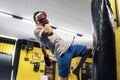 Kickboxing fighter performing Kicks with Knee on punching bag at the gym