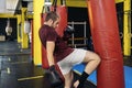 Kickboxing fighter performing Kicks with knee on punching bag at the gym