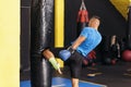 Kickboxing fighter performing Kicks with Knee on punching bag at the gym