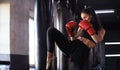 Kickboxing woman in activewear and red kickboxing gloves on black background performing a martial arts kick Royalty Free Stock Photo