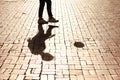 Kicking it by myself. Cropped image of a single pair of legs kicking a soccer ball casting a shadow.