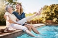 Kicking off summer with a dip in the pool. a happy senior woman spending quality time with her daughter at the pool. Royalty Free Stock Photo