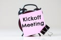 Kickoff Meeting text on a sticker for reminders with an alarm clock Royalty Free Stock Photo