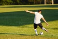 Kicks the ball. Young soccer player have training on the sportive field Royalty Free Stock Photo