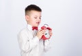 Kid adorable boy white shirt red bow tie. Develop self discipline. Set up alarm clock. Child little boy hold red clock