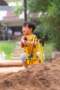 Kid baby boy todler playing construction truck toy diging sand in playground Royalty Free Stock Photo