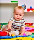 Kid baby boy plying with puzzle toy on floor. Royalty Free Stock Photo