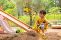 Kid baby boy todler playing construction truck toy diging sand in playground