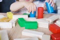 Kid, baby builds towers and buildings from colored wooden figures, the concept of housing construction, mortgage, insurance, happy Royalty Free Stock Photo
