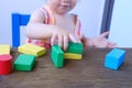 Kid, baby builds towers and buildings from colored wooden figures, the concept of housing construction, mortgage, insurance, happy Royalty Free Stock Photo