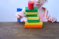 Kid, baby builds towers and buildings from colored wooden figures, the concept of housing construction, mortgage, insurance, happy Royalty Free Stock Photo