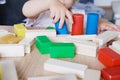 Kid, baby builds towers and buildings from colored wooden figures, the concept of housing construction, mortgage, insurance, happy Royalty Free Stock Photo