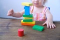 Kid, baby builds towers and buildings from colored wooden figures, the concept of housing construction, mortgage, insurance, happy Royalty Free Stock Photo