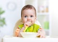 Kid baby eating food on kitchen Royalty Free Stock Photo