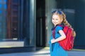 Kid back to school. Happy cute confident girl in uniform. schoolchild in blue dress with red backpack