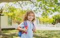 Kid with backpack going to school. Kids education concept. Child with rucksacks standing in the park near school. Pupils
