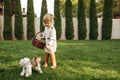 Kid with basket play with funny dog in the garden Royalty Free Stock Photo