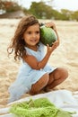 Kid On Beach Portrait. Cute Little Girl With Curly Hair Holding Watermelon. Happy Child Going To Eat On Sandy Coast. Royalty Free Stock Photo