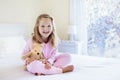 Kid in bed. Winter window. Child at home by snow. Royalty Free Stock Photo