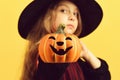 Kid in black witch hat and dress. Girl with pumpkin Royalty Free Stock Photo