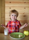 Kid or blonde happy boy eating apple. Royalty Free Stock Photo