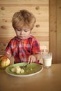 Kid or blonde happy boy eating apple. Royalty Free Stock Photo