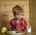 Kid or blonde happy boy eating apple. Royalty Free Stock Photo