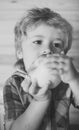 Kid or blonde happy boy eating apple. Royalty Free Stock Photo