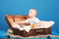 Kid on a blue background sits in a chest in a sailor suit