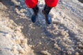 Kid in rainboots jumping in the ice puddle